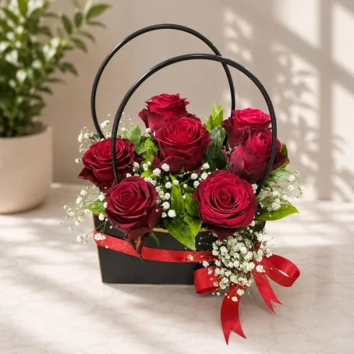 7 rote Rosen in einer Geschenkbox mit Henkel